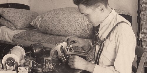 Firmengründer Franz Zingerle repariert etwas in seiner Werkstatt, Archivbild in Sepia-Farben