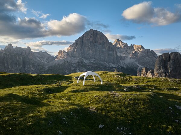Weitwinkel-Aufnahme aus der Vogelperspektive von aufblasbarem Zelt in der Farbe Weiß, im Hintergrund Bergspitzen
