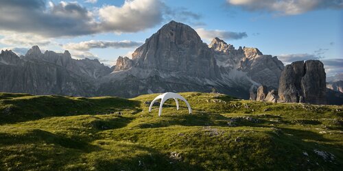 Weitwinkel-Aufnahme aus der Vogelperspektive von aufblasbarem Zelt in der Farbe Weiß, im Hintergrund Bergspitzen
