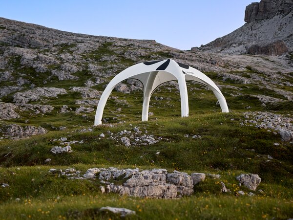 Weißes Zelt zum Aufblasen, schwarz bedruckt, im Hintergrund felsige Berglandschaft