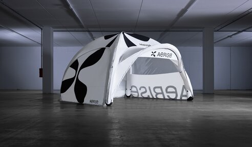 Inflatable advertising tent with sidewalls, awning and custom-printed front banner.