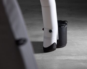 Eine schwarze Wasserballastierungstonne steht neben dem Zeltfuß eines Aerise Zeltes.