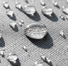 Nahaufnahmen von Wassertropfen auf einem grauen Stoff