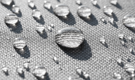 Nahaufnahmen von Wassertropfen auf einem grauen Stoff