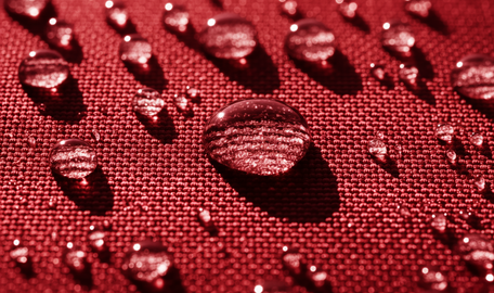 Detalhes de gotas de água sobre um tecido vermelho