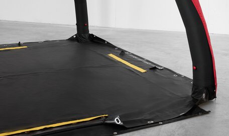 Ein rot-schwarzes aufblasbares Zelt von Aerise, ausgestattet mit Rescue-Boden mit gelben Sicherheitsstreifen