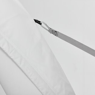 Ein weißes Zelt von Aerise ist mit einem Spanngurt am Untergrund befestigt