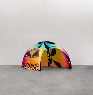 In einer Industriehalle steht ein buntes aufblasbares Zelt von Aerise mit Seitenwänden.