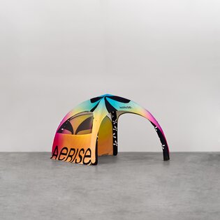 Vor einem neutralen grauen Hintergrund steht ein bunt bedruckter Luftpavillon mit zwei Seitenwänden.