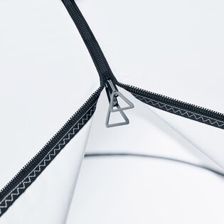 Detailaufnahme eines Reißverschlusses an einem aufblasbaren Zelt in der Farbe Weiß