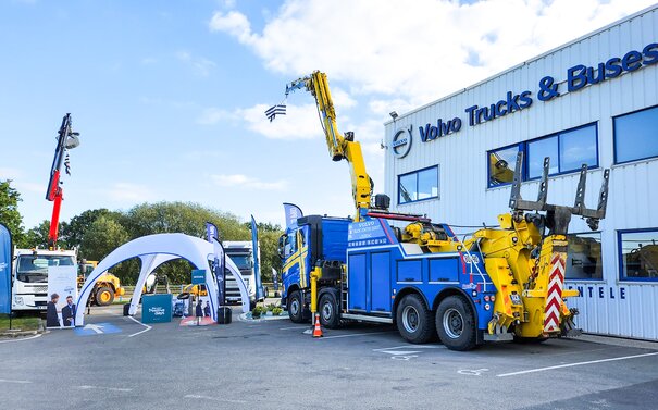 Auf dem Außengelände von Volvo Truck steht ein weißes aufblasbares Zelt neben Lastwagen.
