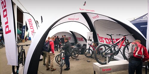 Weißes Zelt mit roter Markenbedruckung auf einer Messe