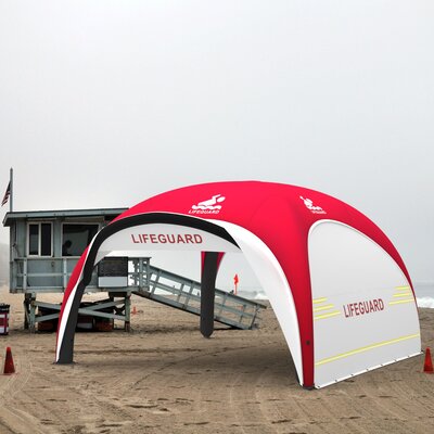 Aufblasbares Rettungszelte in den Farben Rot und Weiß mit Seitenwänden an Strand, trübes Wetter
