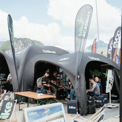 Zwei verschieden große aufblasbare Eventzelte in Schwarz, Logodruck auf dem Dach und den Seitenwände