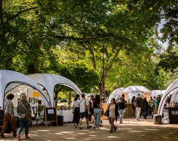 Mehrere weiße aufblasbare Zelte aneinandergereiht auf einem Markt für französische Spezialitäten.
