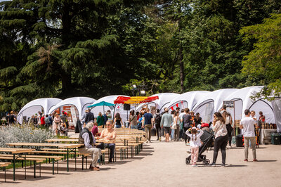 Mehrere weiße aufblasbare Zelte aneinandergereiht auf einem Markt für französische Spezialitäten.
